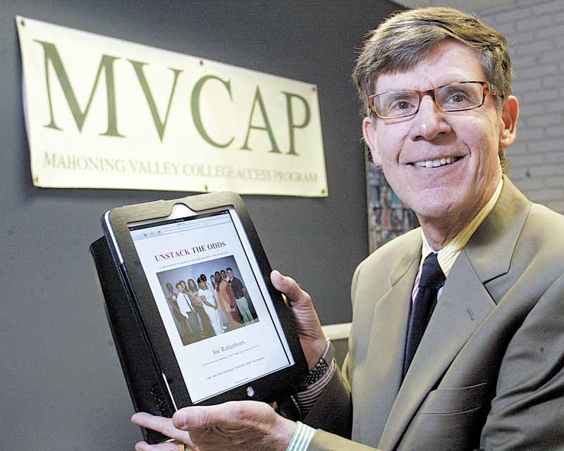 Joe Rottenborn, executive director of Mahoning Valley College Access Program, stands in his offi ce at Kent State University Trumbull Campus holding an iPad displaying a website he has created to help students with getting into and completing college.