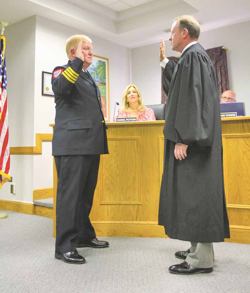 Don Hutchison, left, is sworn in by Judge Scott Hunter as the new chief of Cardinal Joint Fire District, which serves the city of Canfield and Canfield Township. Hutchison joined the district in 1989 and worked with former Chief Robert J. Tieche until Tieche’s death in May. The ceremony was Monday.