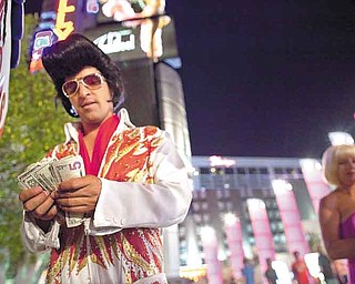 While impersonating Elvis along The Strip, Rodrigo Gonsalez takes a moment to count the night's tip earnings, Thursday, June 23, 2011, in Las Vegas. The number of celebrity impersonators crowding the Las Vegas Strip has grown in recent months, in part because the stalled economy has left many actors and performers in California and Las Vegas without a job.   (AP Photo/Julie Jacobson)