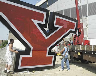 From left, Vinnie Mileto, Ernie Sattarelle and Jess Kovach, all employees with Jenkins Signs of Youngstown, get ready to hoist the large Y on the east side of Youngstown State University’s $10 million Watson and Tressel Training Site.