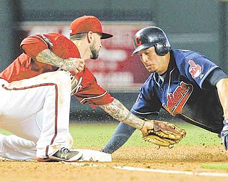 Arizona Diamondbacks' Ryan Roberts, left, tags out Cleveland Indians' Asdrubal Cabrera, as he tries to steal third base during the fourth inning of an interleague baseball game Wednesday, June 29, 2011, in Phoenix. (AP Photo/Ross D. Franklin)