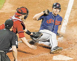 Cleveland Indians' Lou Marson, right, scores ahead of the tag by Arizona Diamondbacks' Miguel Montero as umpire Mike DiMuro, left, looks on during the ninth inning in an interleague baseball game Wednesday, June 29, 2011, in Phoenix. (AP Photo/Ross D. Franklin)