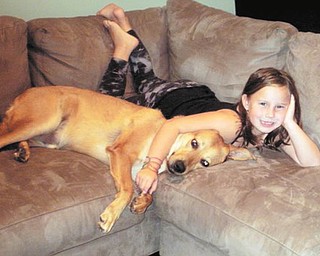 Madalyn Smith of Boardman cuddles with her dog, Bullseye, who was adopted as a puppy from Mahoning County Dog Pound.