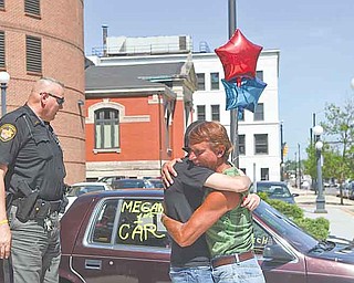 Frank Fordley hugs Richard McGrath’s, a Trumbull County Sheriff’s deputy, daughter, Megan, 16, outside the Trumbull County Sheriff’s Office on High Street in Warren as Richard McGrath looks at the car, a 1992 Dodge Spirit. Fordley runs a music store and car lot on Mahoning Avenue in Champion.