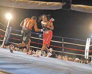 Dannie Williams, right, follows through on a right hook as his opponent, Oscar Cuero, tries to land a right uppercut during Friday’s 10-round lightweight bout outside the Covelli Centre.