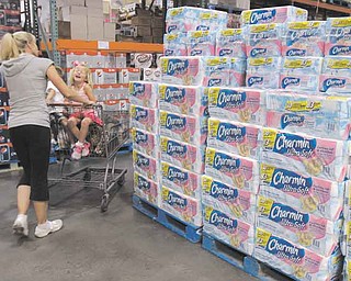 In this June 13, 2011 photo, shoppers buy toilet paper at Costco in Mountain View, Calif. Shoppers go into Costco, TJ Maxx or a DSW shoe store looking for a bargain on something they need and end up splurging on irresistible finds.(AP Photo/Paul Sakuma)