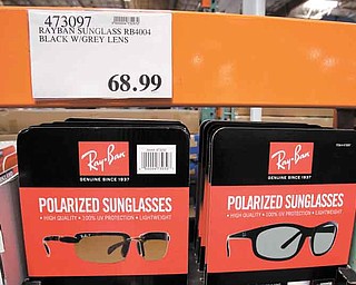 In this June 13, 2011 photo, RayBan sunglasses are displayed at Costco in Mountain View, Calif. Shoppers go into Costco, TJ Maxx or a DSW shoe store looking for a bargain on something they need and end up splurging on irresistible finds.(AP Photo/Paul Sakuma)