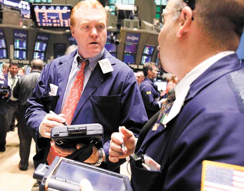 FILE - In this June 22, 2011 file photo, Terence Toal, left, talks to a fellow trader as they work on the floor of the New York Stock Exchange. Global stock markets pushed modestly higher Tuesday, July 5, as investors awaited a raft of U.S. economic data this week that culminates with closely-watched payrolls figures.(AP Photo/Richard Drew, file)