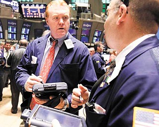 FILE - In this June 22, 2011 file photo, Terence Toal, left, talks to a fellow trader as they work on the floor of the New York Stock Exchange. Global stock markets pushed modestly higher Tuesday, July 5, as investors awaited a raft of U.S. economic data this week that culminates with closely-watched payrolls figures.(AP Photo/Richard Drew, file)