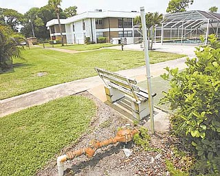 In this June 15, 2011 photo, an empty park bench and rusting pipe sit near the swimming pool at the Inlet House, in Fort Pierce, Fla. The complex was an affordable place that the 55-and-older set aspired to. But now the Homeowner's association has levied a $6,000 assessment on every homeowner and then foreclosed on seniors who did not owe the bank a dime but could not afford the association bill. (AP Photo/J Pat Carter)