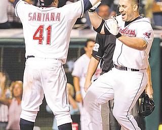 Cleveland Indians' Travis Hafner, right, is greeted at home by teammate Carlos Santana (41) after hitting a walk-off grand slam off Toronto Blue Jays' reliever Luis Perez in the bottom of the ninth inning of a baseball game, Thursday, July 7, 2011, in Cleveland. The Indians won the game 5-4. (AP Photo/Amy Sancetta)