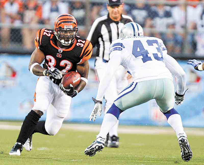 Cincinnati Bengals running back Cedric Benson (32) runs against Dallas Cowboys safety Gerald Sensabaugh (43) in the first quarter of the Hall of Fame NFL football game Sunday, Aug. 8, 2010, in Canton, Ohio. (AP Photo/Mark Duncan)