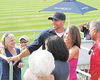 Marine Sgt. Frank Pezzano (in Indians cap) greets family and friends who threw him a surprise homecoming party Friday night at the Scrappers game. At right are his girlfriend, Stephanie Cole, and his father, Frank Pezzano. At left is the sergeant’s mother, Jen.