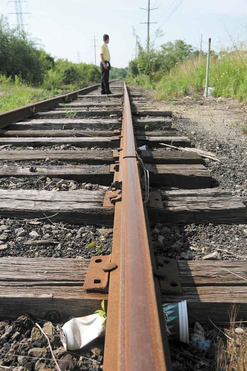 Boardman Township Administrator Jason Loree assesses the amount of trash along the former Youngstown & Southern rail line in the township.