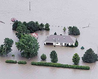 FILE - In this June 13, 2011 file photo, a home is engulfed by flood water in Hamburg, Iowa from the rising Missouri River. Insurance agents in states along the swollen Missouri River basin say federal officials are causing widespread confusion among property owners by pushing the sale of flood insurance policies that might not cover damage from the river flooding. (AP Photo/Nati Harnik, File)