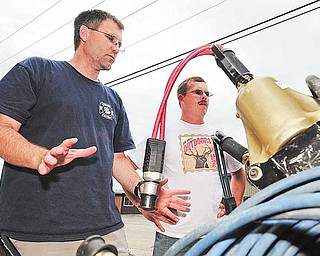 In a July 5, 2011 photo, Brent Anderson, left, and Ken Rackow, both of Goodview, Minn., make safety inspections on the Goodview Fire Department's engine #2. Both Anderson and Rackow were recently laid off from their jobs at Whitewater State Park and have been upping the amount of time they spend volunteering at the Goodview Fire Department because of it. (AP Photo/Winona Daily News, Rory O'Driscoll)