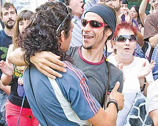 In this Thursday June 16, 2011 photo protesters celebrate after succeeding in stopping the eviction of a man who can't pay his home loan in Parla on the outskirts of Madrid. As in many European countries, Spanish mortgages are not like US-style ones in which defaulters can return the keys to the bank and walk away from their debt, albeit with their credit rating in ruins. Here, mortgage holders not only have to give the house back, but also pay off bank debt. If they cannot, upon their death it is passed on to their children. (AP Photo/Paul White)