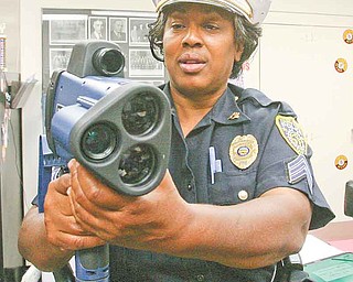 Youngstown Police Detective Sgt. Anita Davis demonstrates the laser radar gun with camera and video that Youngstown police plan to train residents to use. Police Chief Jimmy Hughes argues the new program will be more eff ective than placing warning signs about speeding in city neighborhoods.