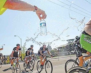 Volunteers pass bottles of water to racers during the men’s Criterium on the final day of the 2011 Tour of the Valley on Sunday afternoon. More than 340 cyclists took part in the event.