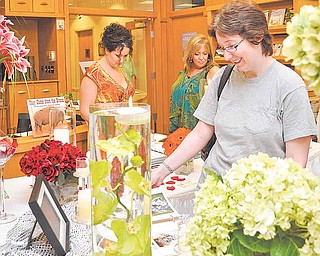 Bride-to-be Emily Smith of Warren, foreground, and Sarah Hahn, left, with mom, Barbara, view samples of flower arrangements from A Floral Aff air at the 2011 Bridal Fair at the D.D. and Velma Davis Education and Visitor Center at Fellows Riverside Gardens, Mill Creek MetroParks, Youngstown.