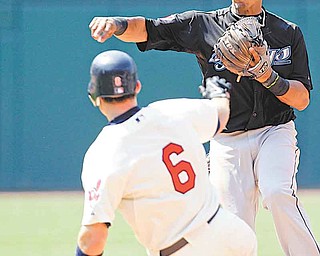 Toronto Blue Jays shortstop Yunel Escobar, back, throws out Cleveland Indians' Jack Hannahan at first after getting out Lou Marson (6) at second for the double play during the eighth inning of a baseball game, Sunday, July 10, 2011, in Cleveland. The Blue Jays won 7-1. (AP Photo/Tony Dejak)