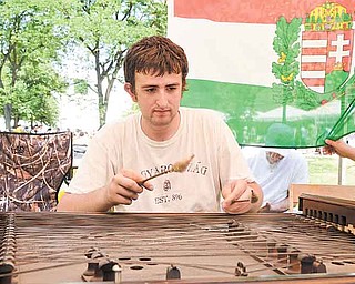 Andrew Check, 18, of Youngstown plays the cimbalom, a Hungarian instrument, during YSU’s Summer Festival of the Arts. Check played the song “Priest Pipe” on Sunday as others sang along during the final day of the event.