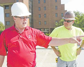 Danny O’Connell, director of support services at Youngstown State University, left, and Ron Williams of Suburban Construction of Cleveland look over the work Monday at the parking deck on Lincoln Avenue on campus. The project is on schedule.