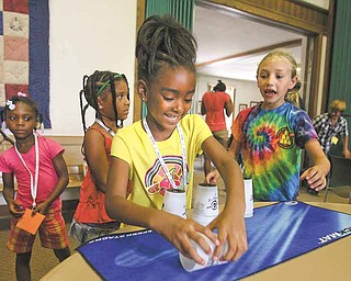 Savannah Kitchen, 6, of Youngstown gets a reaction from Christine Innocenzi, 9, right, as she fumbles a cup while practicing speed stacking after a demonstration Tuesday by Andy Innocenzi, a member of Team USA sport stackers. Other campers watch. Andy’s siblings assisted at the program and also include Laura, 16, and Anthony, 11.