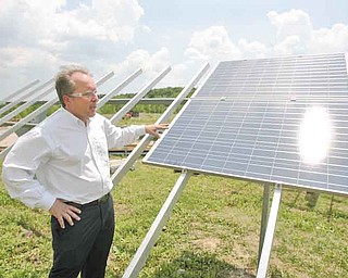 Bernie Petro, director of engineering at Northern States Metals Co., Youngstown, shows how the flex racks his company makes can accommodate many types of solar panels. The company, which originally produced aluminum extrusions, has adapted to create green jobs in the Mahoning Valley.