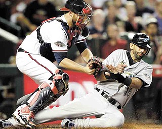 American League's Jose Bautista of the Toronto Blue Jays is tagged out at home plate by National League's Brian McCann of the Atlanta Braves after trying to score on a hit by American League's Adrian Beltre of the Texas Rangers during the fourth inning of the MLB All-Star baseball game Tuesday, July 12, 2011, in Phoenix. (AP Photo/David J. Phillip)
