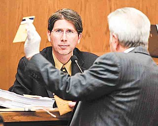 Prosecuting attorney Richard Bombik, right, holds up evidence for evidence investigator Curtiss Jones during the trial of Anthony Sowell Wednesday, July 13, 2011, in Cleveland. Sowell, charged with killing 11 women, has has pleaded not guilty. He could face the death penalty if convicted. (AP Photo/Marvin Fong, Pool)