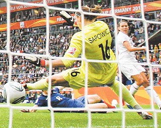 United States' Lauren Cheney scores the opening goal past France goalkeeper Celine Deville during the semifinal match between France and the United States at the Women’s Soccer World Cup in Moenchengladbach, Germany, Wednesday, July 13, 2011. (AP Photo/Frank Augstein)