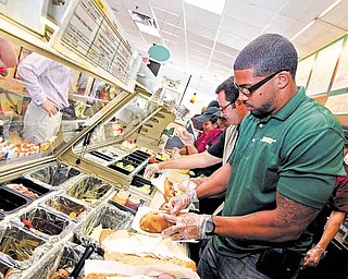Houston football star Arian Foster prepares BBQ Pulled Pork sandwiches for fans at a Subway restaurant at the Subway All-Star BBQ in Los Angeles. Subway is one of several fast-food restaurants updating its look.