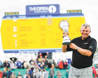 Northern Ireland's Darren Clarke holds the Claret Jug trophy in front of the scoreboard on the 18th green as he celebrates winning the British Open Golf Championship at Royal St George's golf course Sandwich, England, Sunday, July 17, 2011. (AP Photo/Peter Morrison)