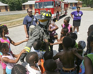 JESSICA M. KANALAS | THE VINDICATOR..Firefighter Shaun Rosan from Engine 12 dresses up in his uniform and lets the kids touch him and talk to him. The firemen came out to teach the kids not to be afraid of the fire trucks and emergency personnel they see on a daily basis. ..-30-