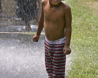JESSICA M. KANALAS | THE VINDICATOR..Edwin, 4, who was too shy to share his last name, stands soaked after playing in the water from the hose of Engine 12 of the Youngstown Fire Department. City Youth director Andrea Mahone runs summer activities for the children in the Plaza View Apartment complex, which is the only public housing in the city without a Youth Center. Mahone said the program, called "Increase the Peace," was implemented into the community to "make them respect and love the city of Youngstown."..-30-