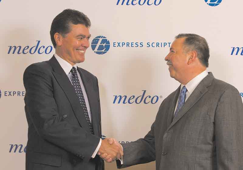 In this photo provided by Express Scripts, David Snow, CEO of Medco Health Solutions, left,  and George Paz, CEO of Express Scripts, shake hands Thursday July 21, 2011, after conclusion of negotiations to merge the two companies.  The new company will be known as Express Scripts with headquarters in St. Louis, Mo.  (AP Photo/Express Scripts, Karen Elshout)
