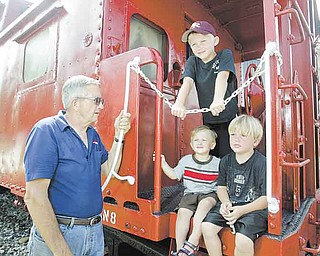 Jack Crouse, owner of Crouse Mills True Value in North Lima, stands with his grandsons, clockwise from top, J.D., Heath and Carson, standing on an old railroad car at his store. Crouse serves on the committee for the Beaver Township bicentennial celebration that begins Tuesday.