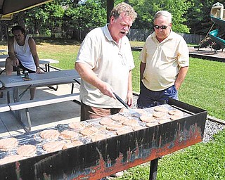 Chuck Kettring & John Rudy grill hamburgers for memeber of the Members of Youngstown Eastside Friends & Family during a picnic Saturday afternoon in Youngstown.