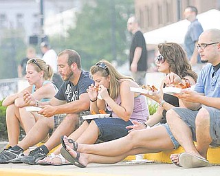 From left, Erin Simione of Boardman and Struthers residents Dan Monico, Jamie Rivello and Bridget and Bill Bowes take a break Saturday evening to enjoy chicken wings at the Greater Youngstown Wing Fest outside Covelli Centre.