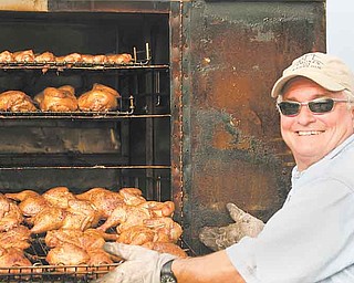 JESSICA M. KANALAS | THE VINDICATOR..Eddy Erhardt of Poland shows off his food options at his tent at the Wing Fest in Youngstown. Erhardt owns the Eddy's Smoken Pit BBQ and Grill which opened in 1975. "We started with a pick-up truck and a grill," he said. "I wish every day was like today."..-30-