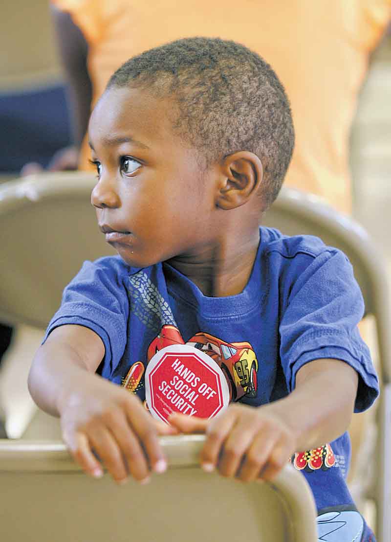 Two-year-old Jordan Jackson of Youngstown wears his “Hands off Social Security” sticker as he waits for Sunday’s town-hall meeting at the Union Baptist Church in Youngstown to begin. The meeting discussed the impact of possible cuts to Social Security, Medicare and Medicaid.