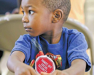 Two-year-old Jordan Jackson of Youngstown wears his “Hands off Social Security” sticker as he waits for Sunday’s town-hall meeting at the Union Baptist Church in Youngstown to begin. The meeting discussed the impact of possible cuts to Social Security, Medicare and Medicaid.