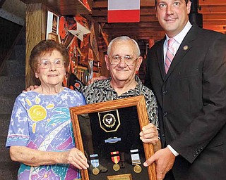 Korean War veteran Donald Lariccia stands in his Austintown home with his wife, Mary, and receives his service medals from U.S. Rep. Tim Ryan.