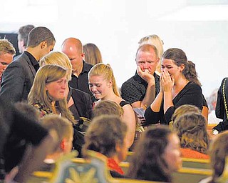 People react at the end of a service at Oslo Cathedral Sunday July 24, 2011, in the aftermath of the Friday terror attacks on Norway's government headquarters in Oslo and a youth retreat on Utoya island. Police said Sunday they are conducting an operation in a residential neighborhood of Oslo, and police spokesman Anders Fridenberg would give no other details about the action. Survivors of the massacre have said there were two assailants, and police have said they were looking into those accounts and had not ruled out a second suspect. (AP Photo/Matt Dunham)