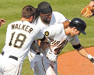 Pittsburgh Pirates' Chase d'Arnaud, right, celebrates with teammates Andrew McCutchen, center, and Neil Walker (18) after hitting a walkoff sacrifice fly to score the winning run in the tenth inning of a baseball game against the St. Louis Cardinals in Pittsburgh, Sunday, July 24, 2011. The Pirates won 4-3. (AP Photo/Gene J. Puskar)