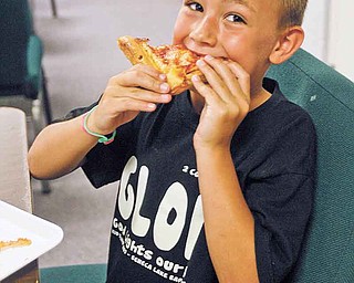 Blase Schuller, 6, of Champion, enjoys his lunch Tuesday at the church, which offered pizza for lunch.
