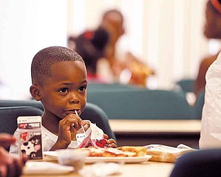 Four-year-old Kenny Byrd drinks the milk offered with his lunch Tuesday at the program in Warren. An average of 50 children age 1 to 18 attend the meal each day. It is one of several such programs that operate in the Mahoning Valley in the summer.
