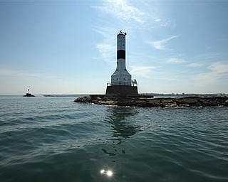 In this photo taken Wednesday, July 20, 2011, the lighthouse standing at the entrance to Conneaut Harbor is shown in Conneaut, Ohio. The Coast Guard conducted a tour for interested parties in preparation for the auctioning of the property. (AP Photo/The Plain Dealer, Thomas Ondrey)
