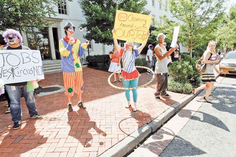 Washington residents, dressed as clowns, take part in a jobs demonstration outside of the Cannon House Office Building on Capitol Hill in Washington Wednesday, July 27, 2011.(AP Photo/Jose Luis Magana)